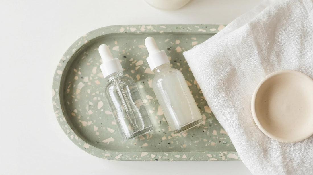 Two glass bottles representing water based vs silicone lubricant options for intimate wellness device compatibility