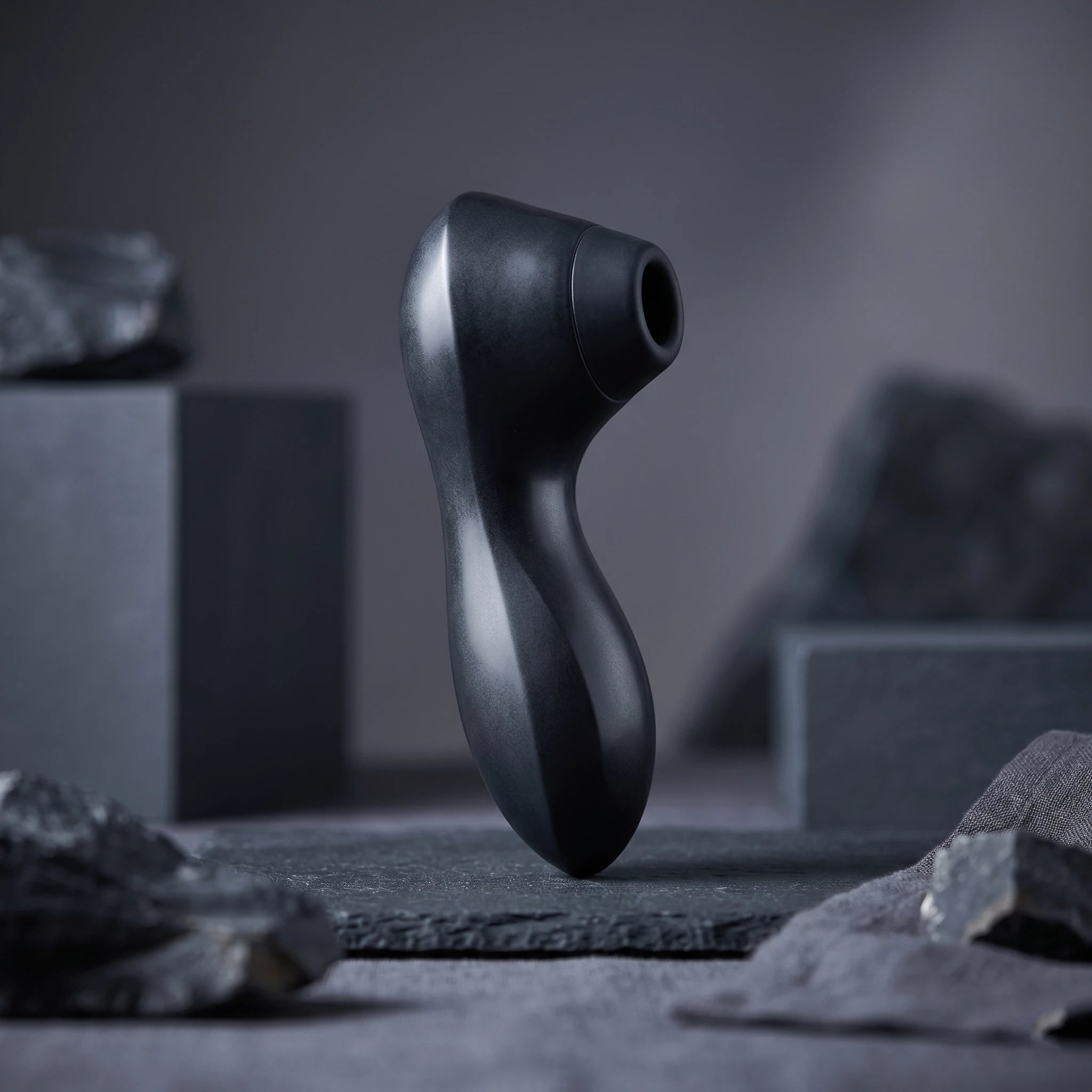 Clitoral suction vibrator styled on dark stone in a modern luxury setting