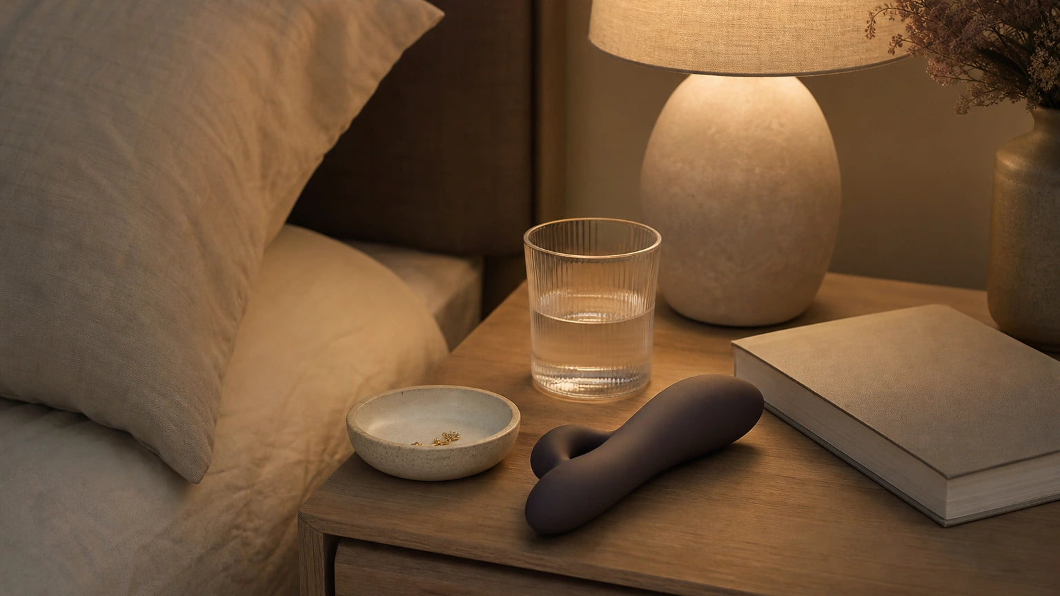 Discreet nightstand with a sculptural body-safe silicone vibrator styled as part of a calming bedtime routine