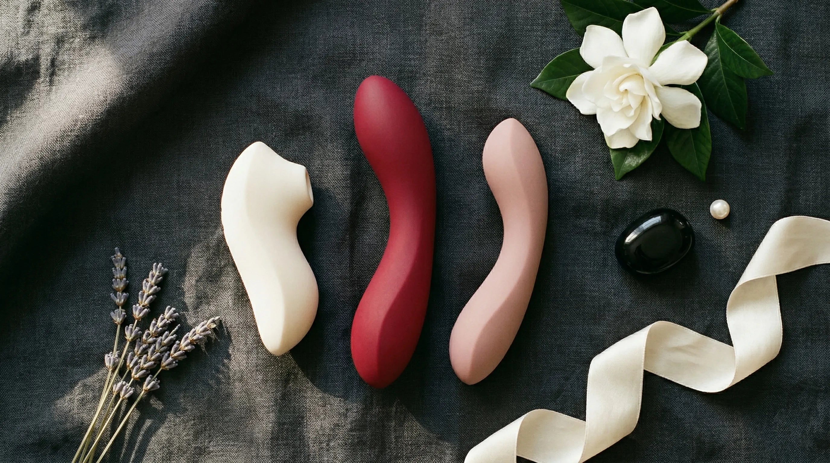 Luxury vibrator collection — sculptural medical-grade silicone designs in ivory, ruby, and rose