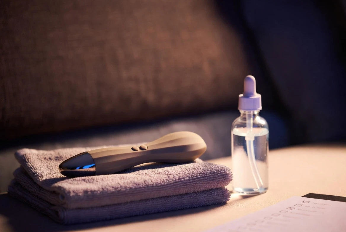 Bedside orgasmic massage troubleshooting setup with discreet device, lubricant, and soft towel
