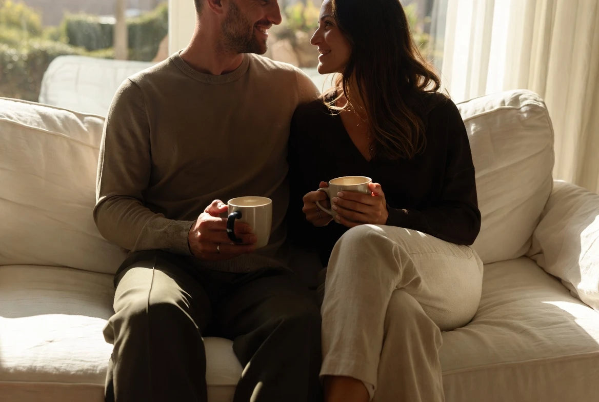 Two people sitting close together on a sofa — the physical touch love language expressed through quiet proximity