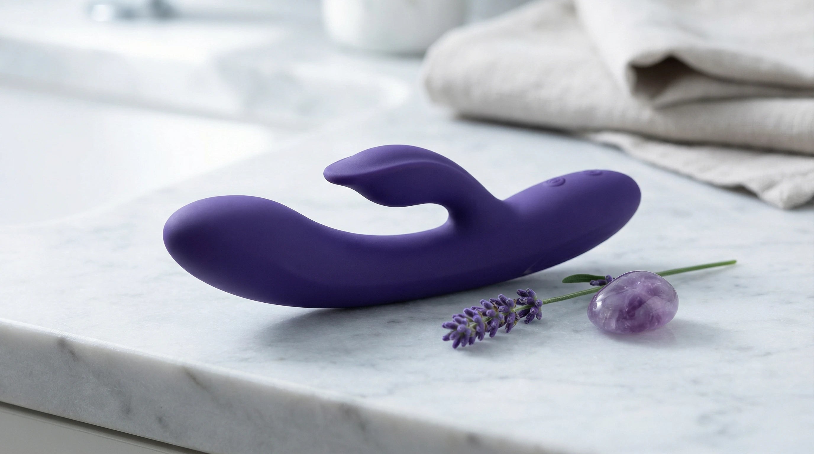 Deep violet silicone vibrator with amethyst and lavender — luxury wellness aesthetic
