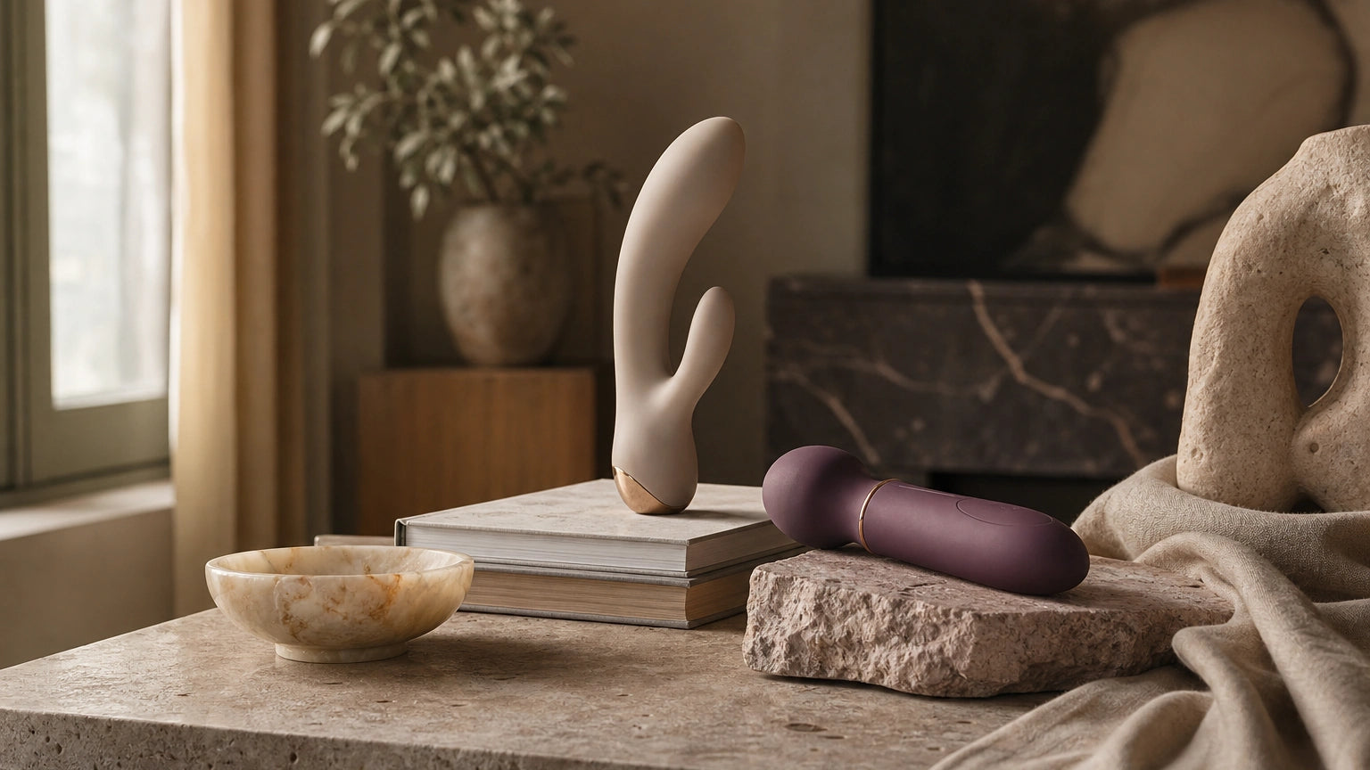 Sculptural vibrator and silicone massager styled with art books and stone decor