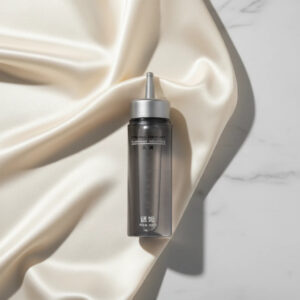 Xindari Silk premium water-based lubricant bottle displayed on an elegant silk and marble background